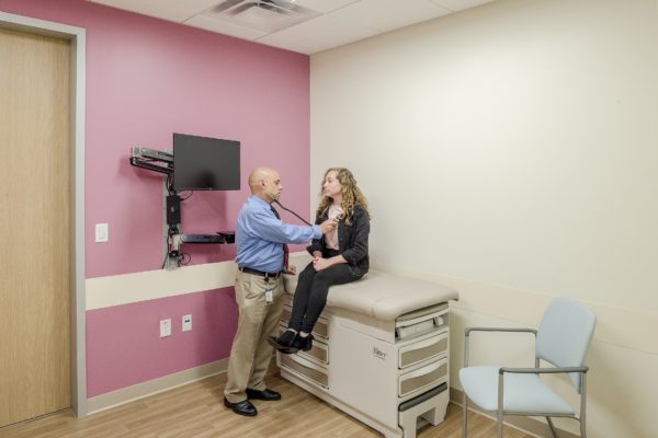Dr. J. Thomas Megerian, pediatric neurologist and medical director of the Thompson Autism Center, examines a patient using a stethoscope