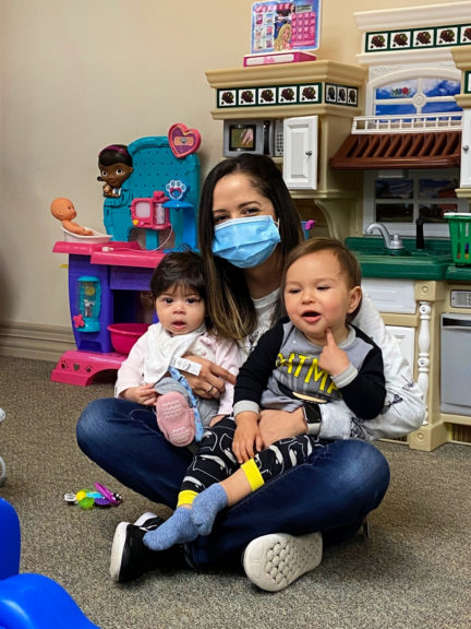 A child life specialist sits with two children enrolled in CHOC's on-campus daycare for staff.