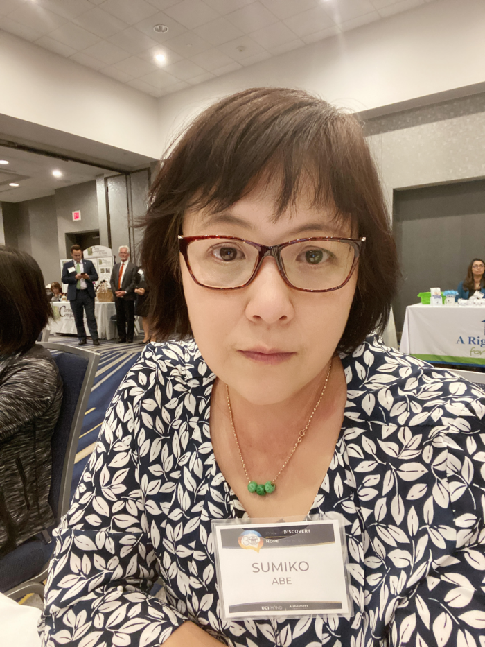 Woman with glasses at a conference with a name tag on